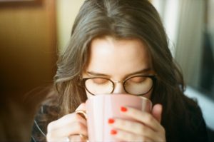 Девушка в очках пьет чай