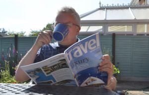 Мужчина с журналом пьет чай